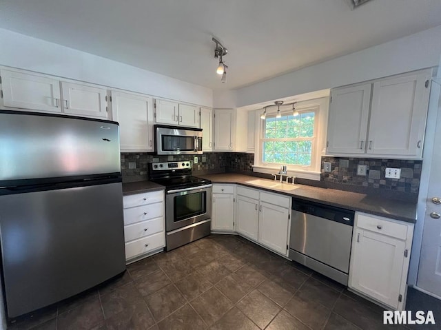 kitchen with backsplash, stainless steel appliances, white cabinets, and sink