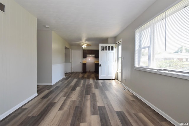 unfurnished living room with dark hardwood / wood-style floors and ceiling fan