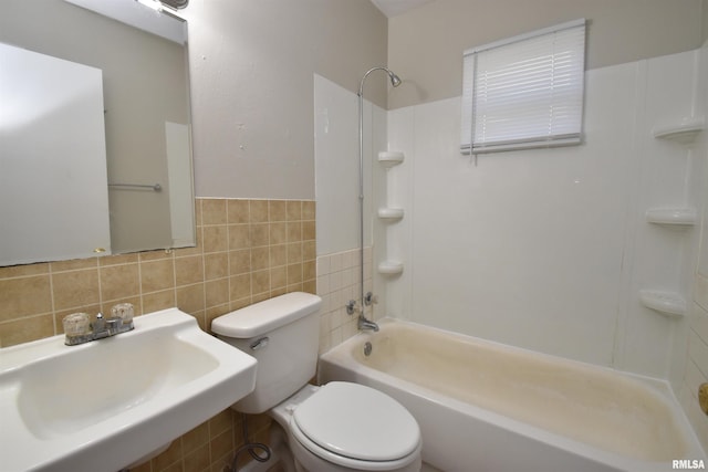 full bathroom featuring toilet, sink, shower / washtub combination, and tile walls