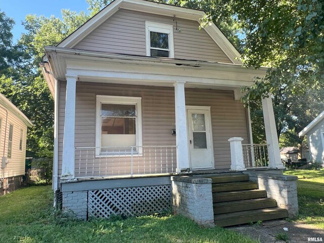 view of front of home featuring covered porch and a front yard