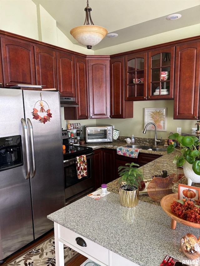 kitchen with sink, vaulted ceiling, stainless steel appliances, decorative light fixtures, and light stone countertops