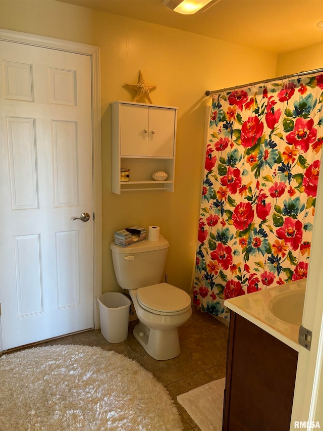 bathroom with a shower with shower curtain, tile patterned floors, vanity, and toilet