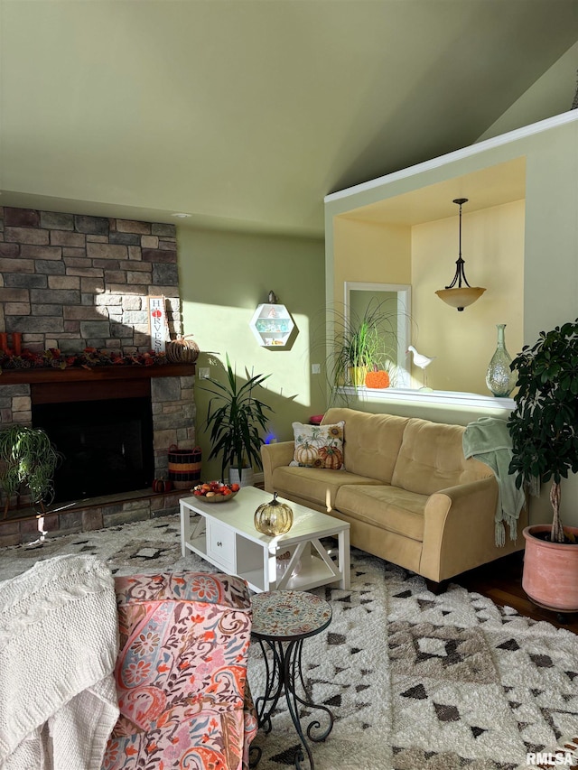 living room featuring a stone fireplace and lofted ceiling