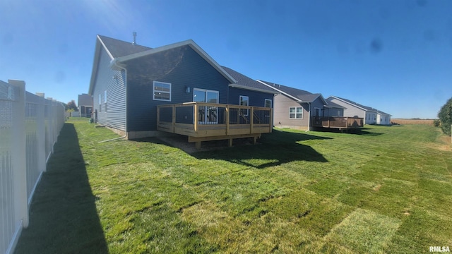 back of property featuring a deck and a lawn