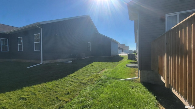 view of home's exterior featuring central AC unit and a yard