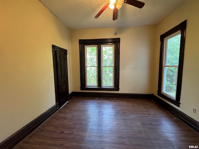 spare room with ceiling fan, dark hardwood / wood-style flooring, and a textured ceiling