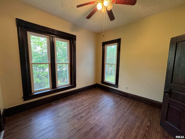 unfurnished room with ceiling fan, a textured ceiling, and dark hardwood / wood-style flooring