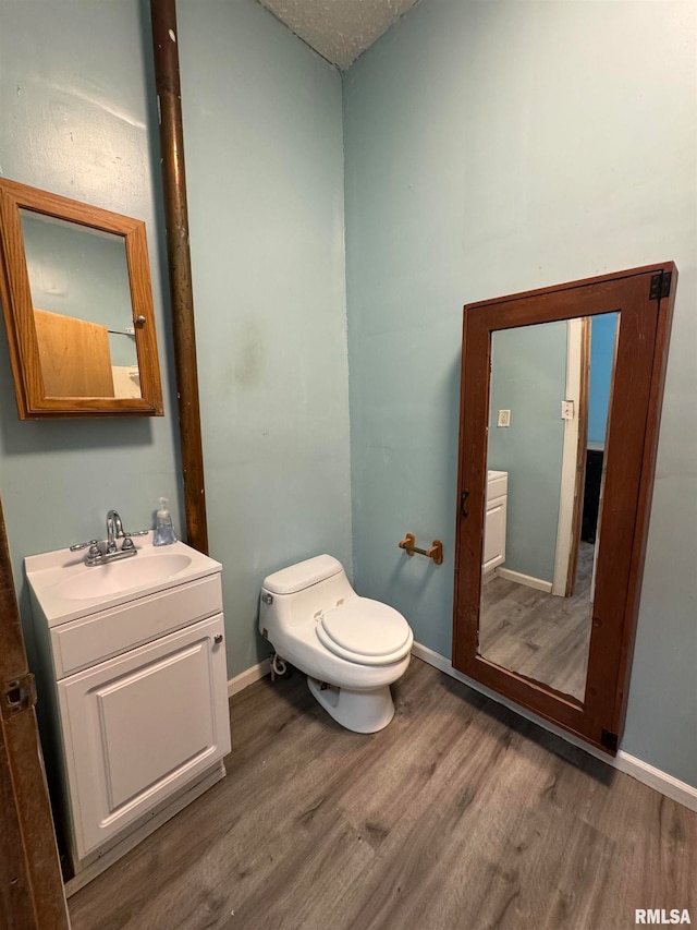 bathroom featuring vanity, toilet, and hardwood / wood-style flooring