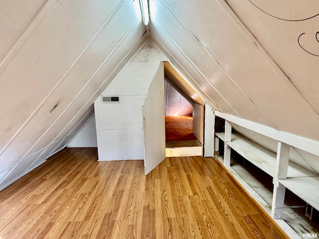 bonus room with vaulted ceiling and hardwood / wood-style flooring