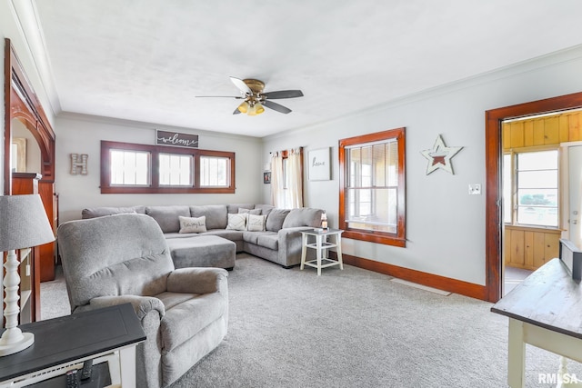 carpeted living room featuring ornamental molding, ceiling fan, and plenty of natural light