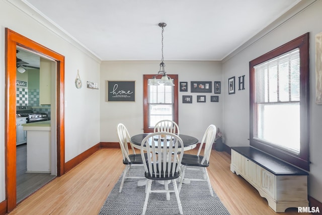 dining area with a healthy amount of sunlight, crown molding, and light hardwood / wood-style floors