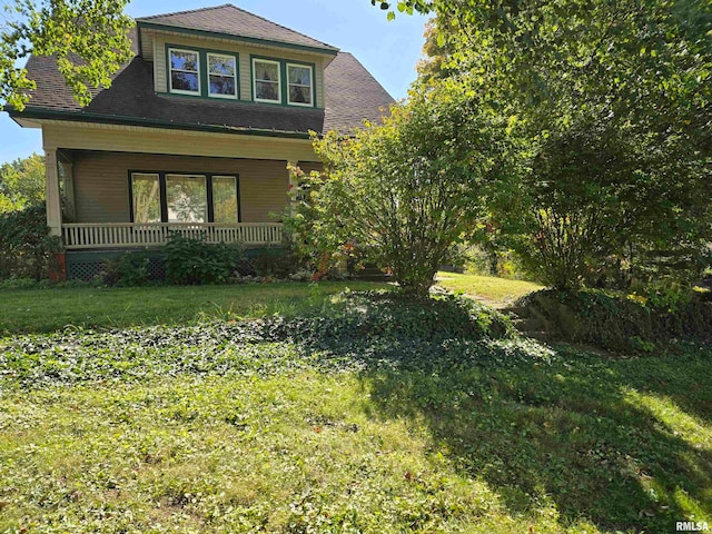 view of front of house with a porch and a front lawn