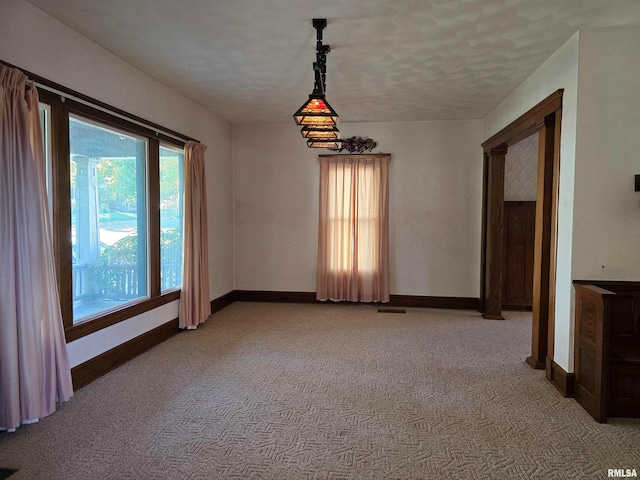 unfurnished room with light carpet and a textured ceiling