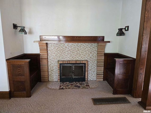 interior details featuring a fireplace and carpet