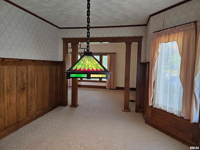 interior space featuring light carpet, crown molding, and decorative columns