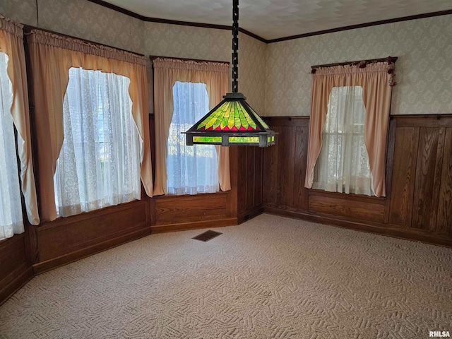 interior space featuring wood walls, crown molding, carpet, and a textured ceiling