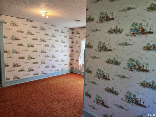 carpeted empty room with a textured ceiling