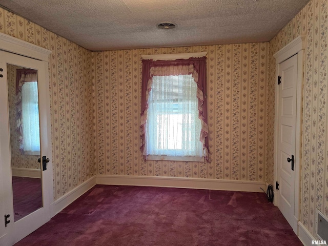 unfurnished room featuring carpet floors and a textured ceiling