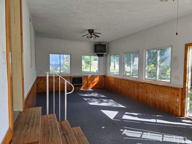 unfurnished sunroom with ceiling fan and plenty of natural light