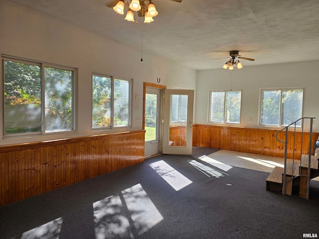 unfurnished sunroom featuring ceiling fan and plenty of natural light