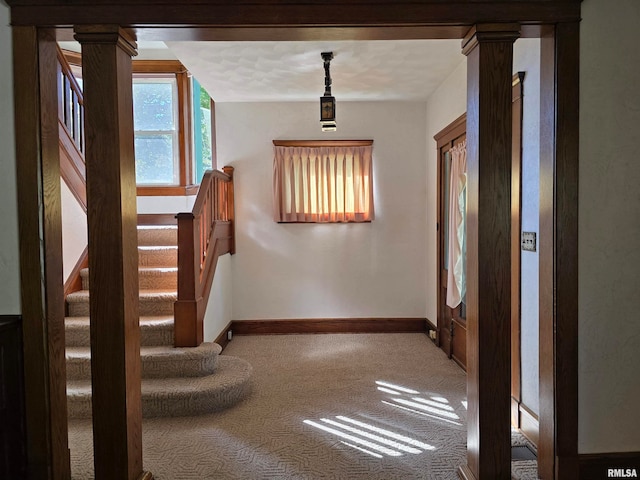 interior space featuring carpet floors and ornate columns