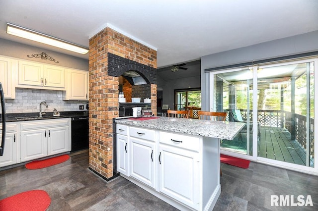 kitchen with a center island, decorative backsplash, ceiling fan, and white cabinets