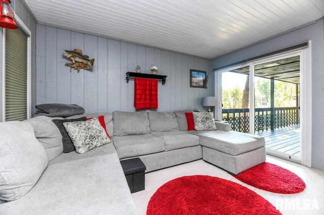 living room featuring wooden ceiling, wood walls, and light wood-type flooring