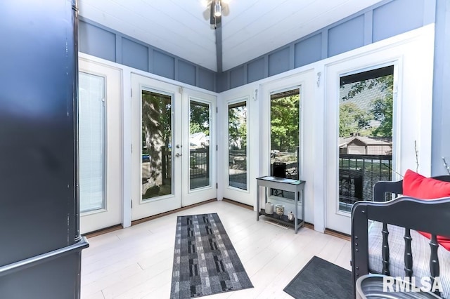 doorway featuring light hardwood / wood-style floors and lofted ceiling