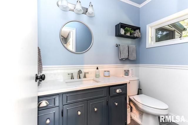 bathroom featuring ornamental molding, vanity, and toilet