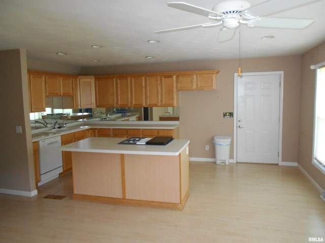 kitchen featuring white dishwasher, light wood-type flooring, sink, and a center island