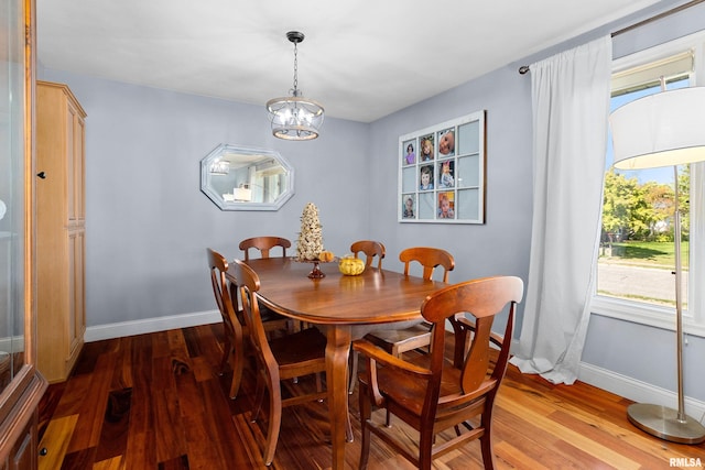 dining area featuring wood-type flooring and a chandelier