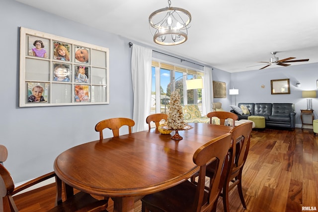 dining area with ceiling fan with notable chandelier and dark hardwood / wood-style flooring