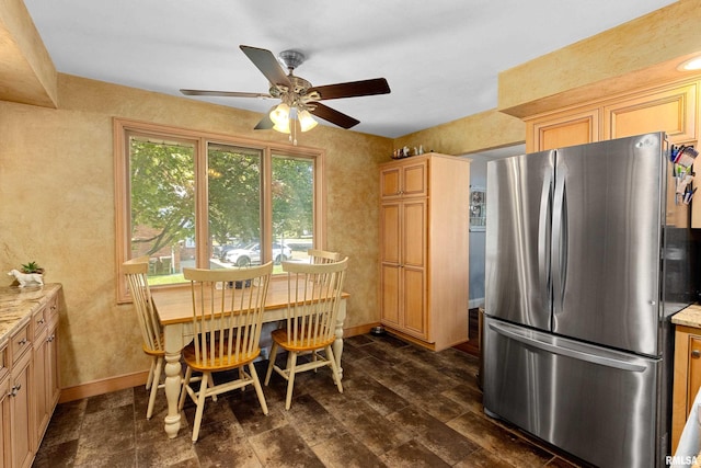 kitchen featuring stainless steel refrigerator, ceiling fan, dark wood-type flooring, light brown cabinets, and light stone counters