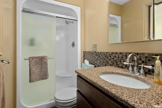 bathroom featuring walk in shower, vanity, toilet, and decorative backsplash