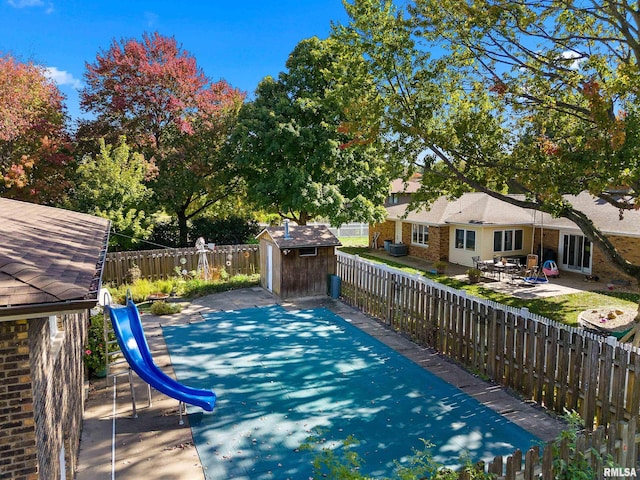 view of pool featuring a patio area and a storage unit