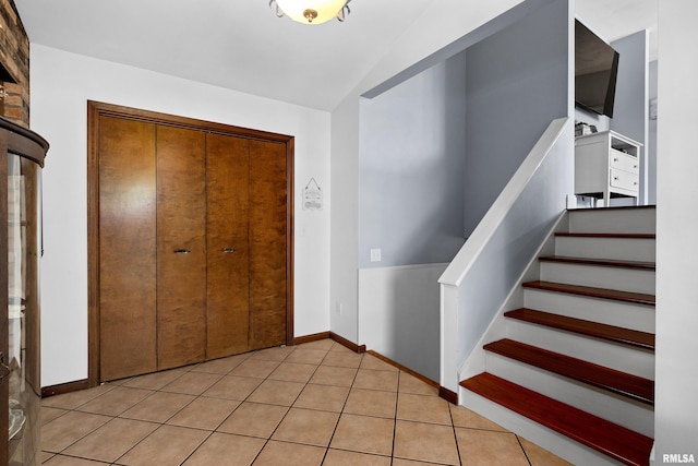 entrance foyer with lofted ceiling and light tile patterned floors