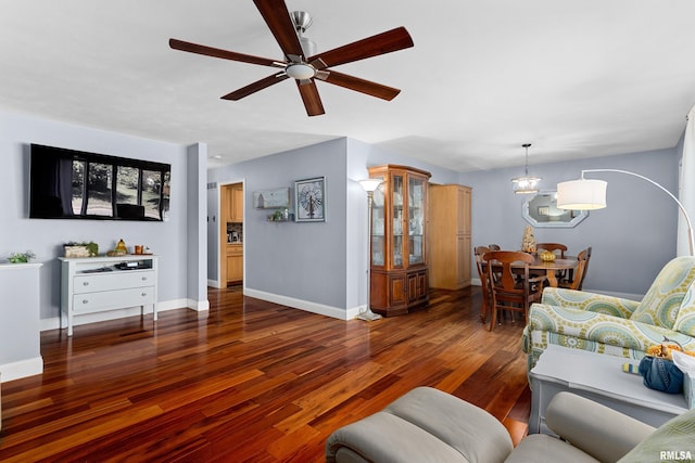 living room featuring ceiling fan with notable chandelier and dark hardwood / wood-style floors