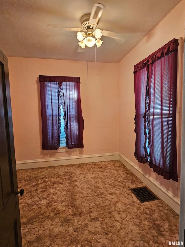 carpeted spare room with a healthy amount of sunlight and ceiling fan