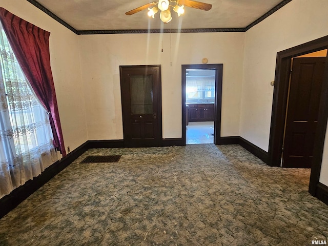 empty room featuring ceiling fan, ornamental molding, and carpet flooring