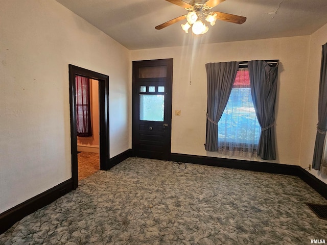 entryway with ceiling fan and carpet floors