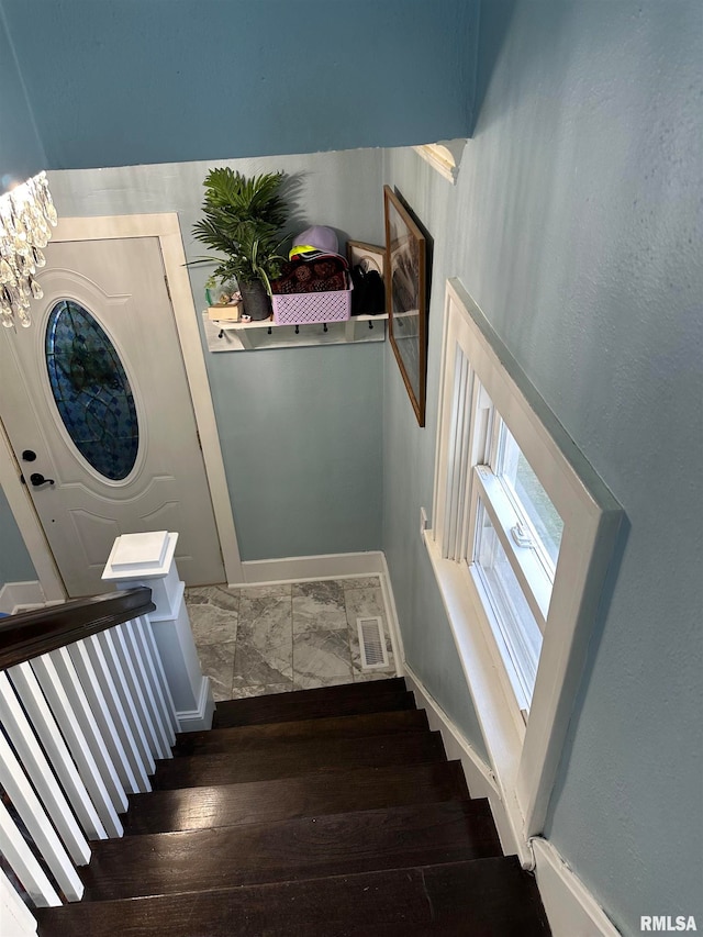 staircase with a chandelier and hardwood / wood-style flooring