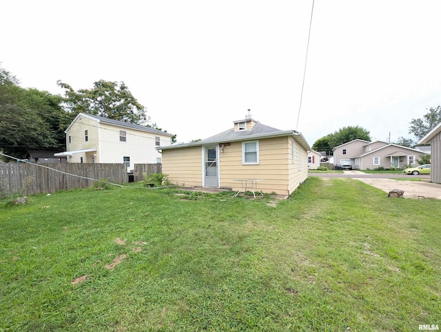 rear view of house featuring a lawn