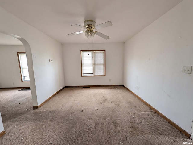 unfurnished room with ceiling fan, a healthy amount of sunlight, and light carpet