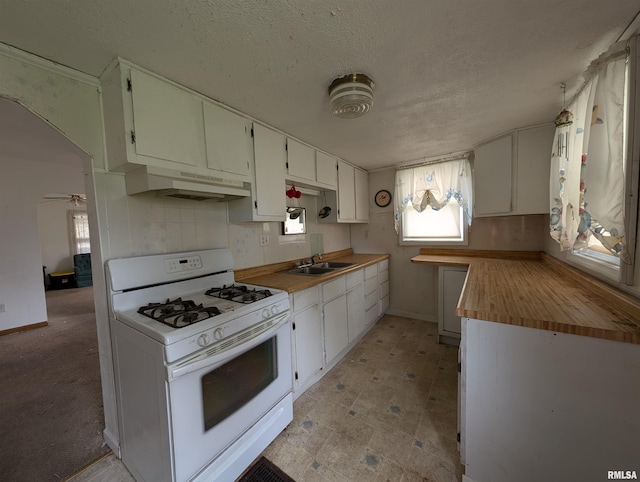 kitchen with white cabinets, ceiling fan, white gas range oven, and a textured ceiling