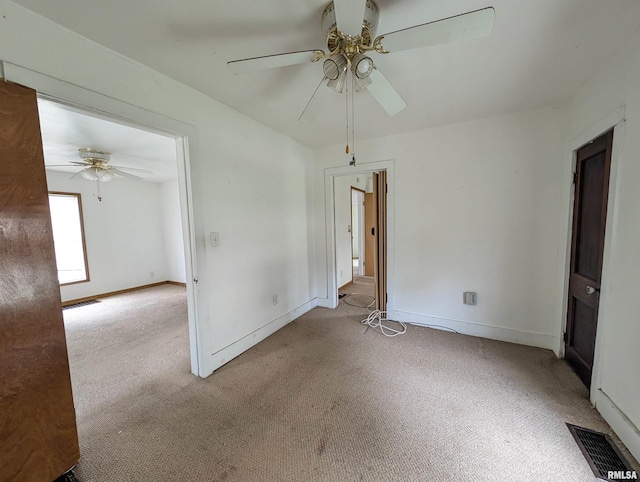 spare room featuring ceiling fan and light carpet