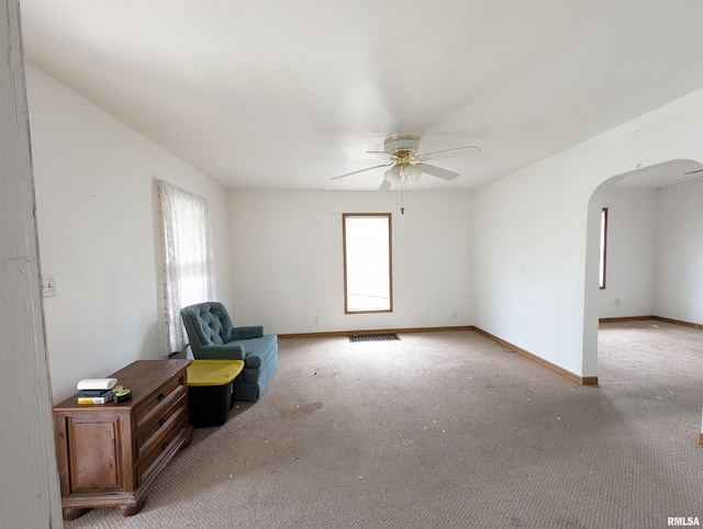 unfurnished room with light colored carpet and ceiling fan