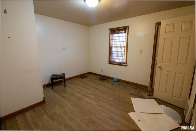 spare room with hardwood / wood-style floors and a textured ceiling