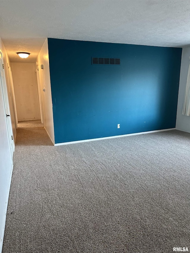 carpeted spare room featuring a textured ceiling