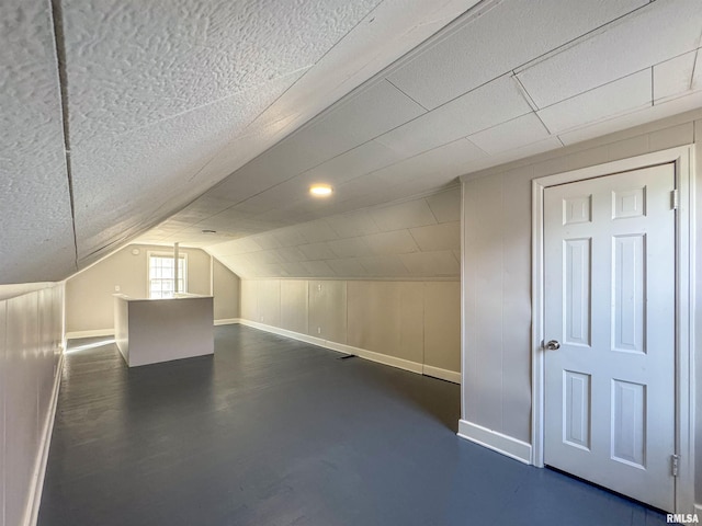 additional living space featuring lofted ceiling and a textured ceiling