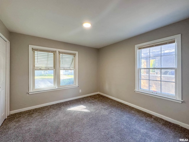 unfurnished room with carpet floors and plenty of natural light